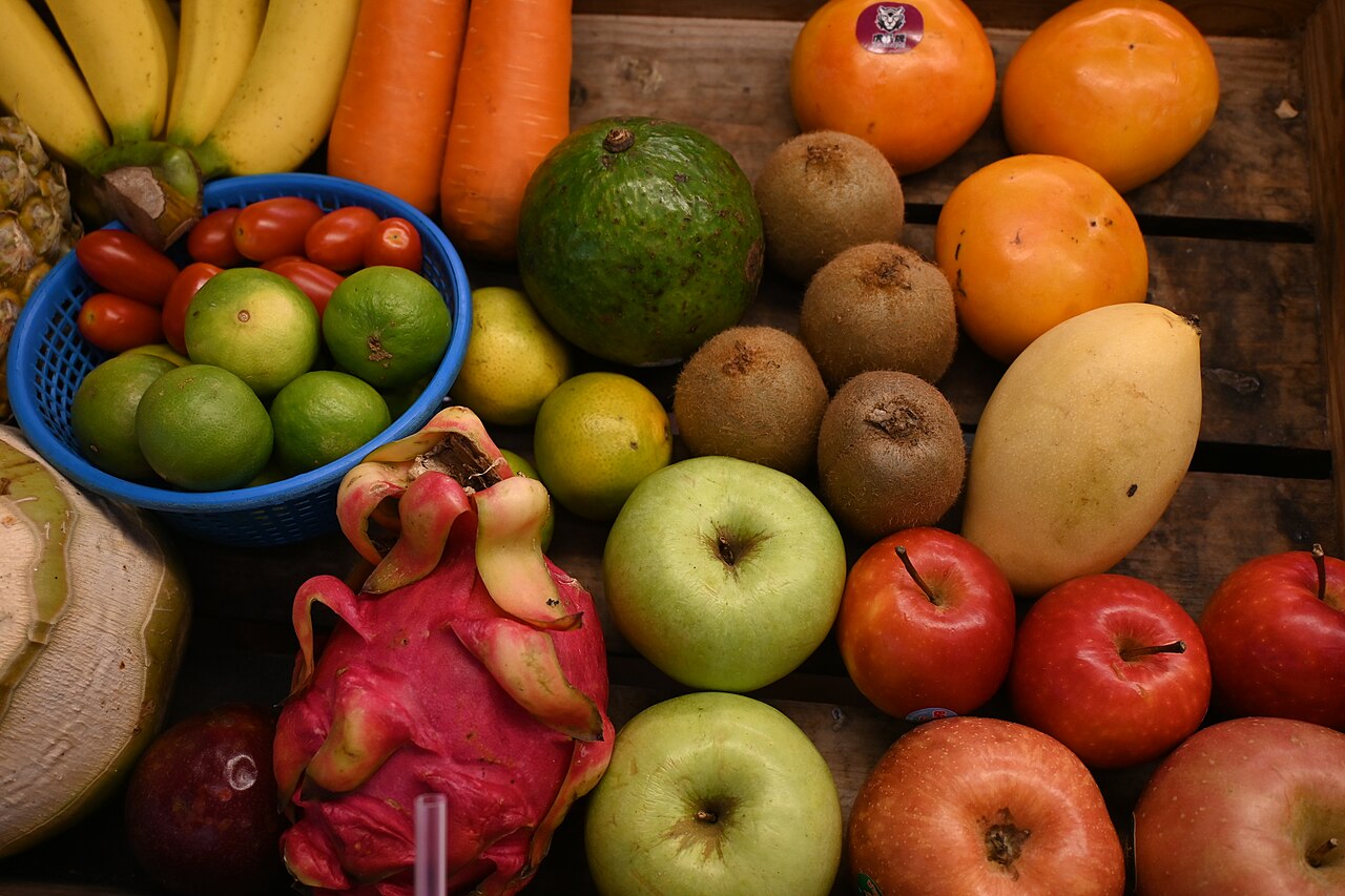 A colorful assortment of fresh fruits and vegetables arranged on a wooden crate
