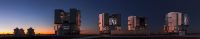 A large astronomical telescope observatory silhouetted against a colorful twilight sky