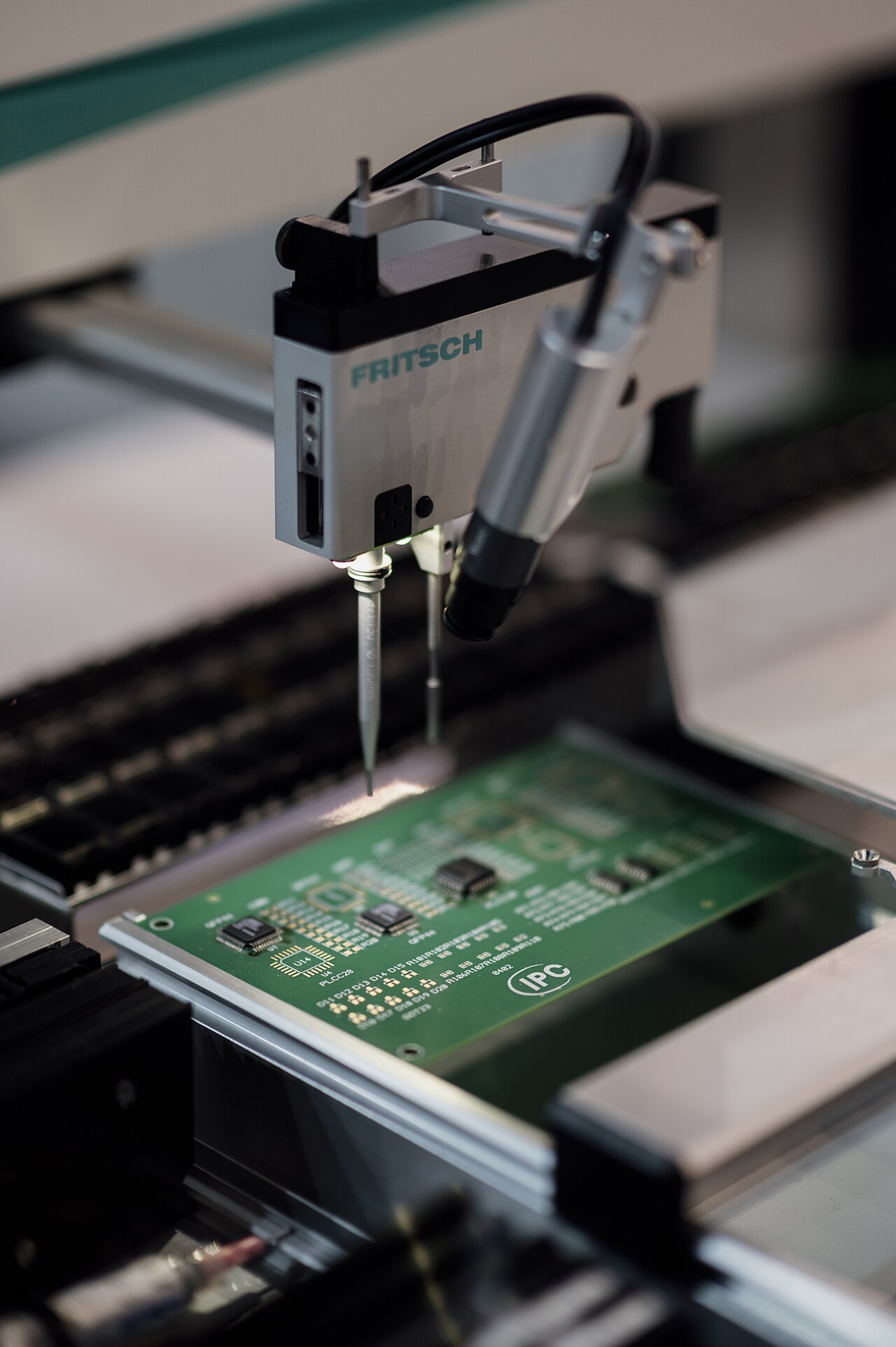 An automated machine placing electronic components onto a circuit board during manufacturing