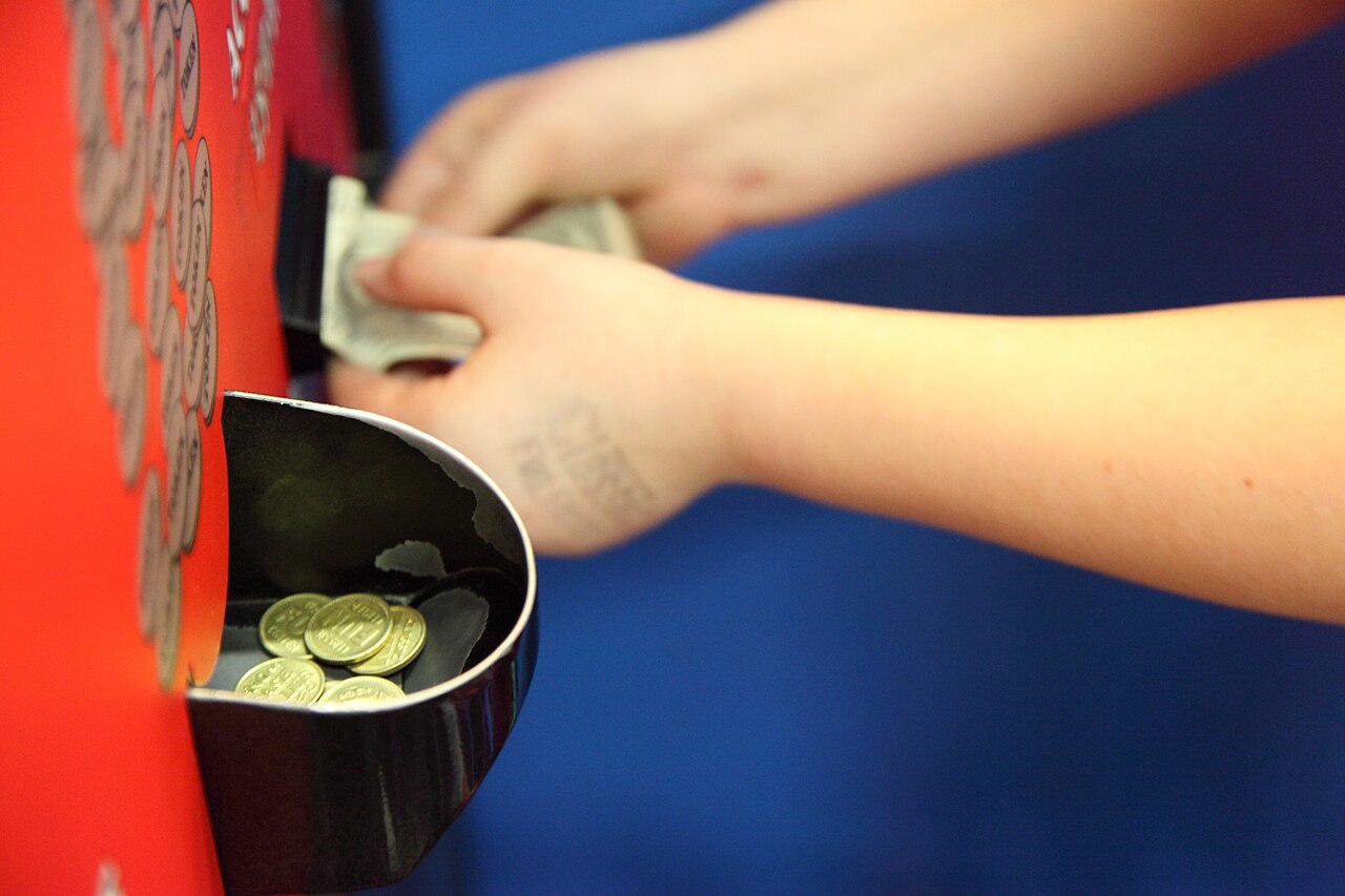 A child putting money into an arcade token change machine to receive tokens