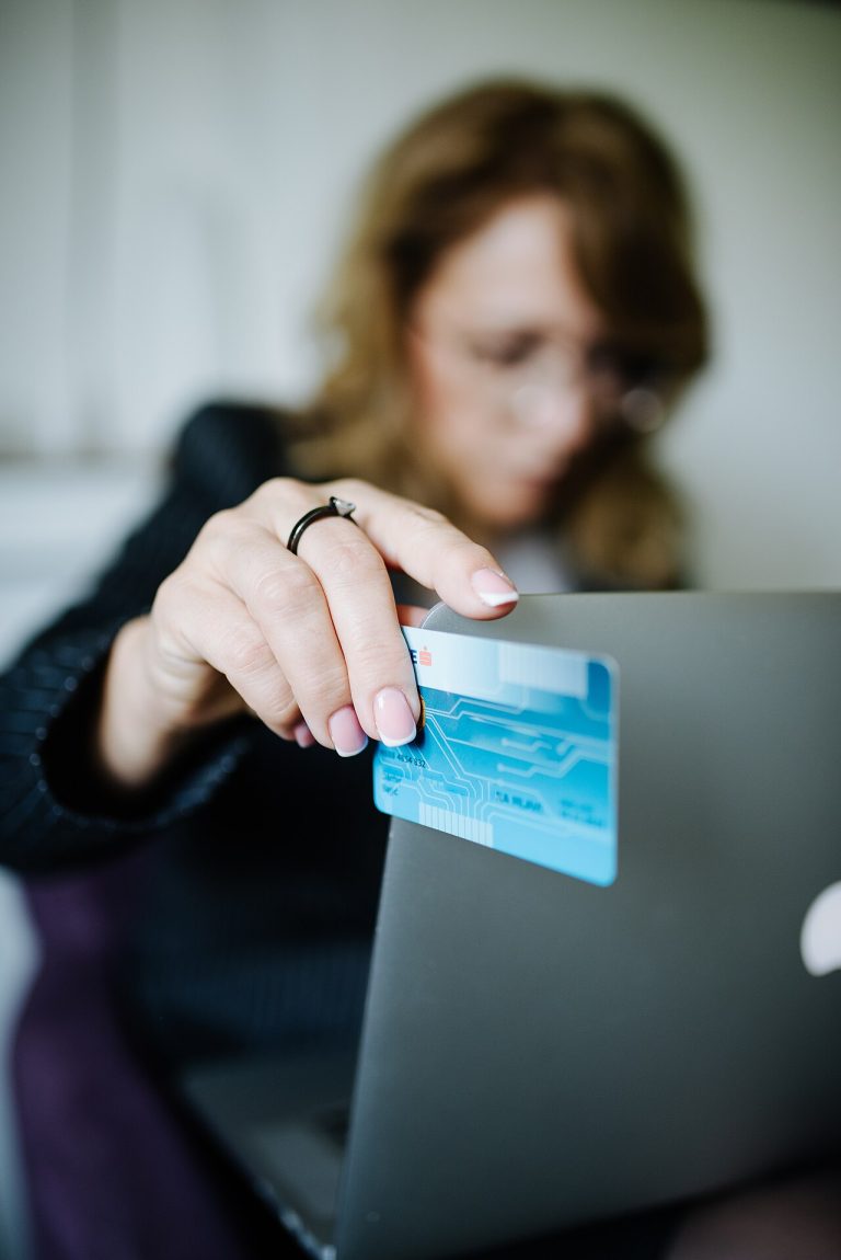 A person using a credit card to make an online purchase on a laptop