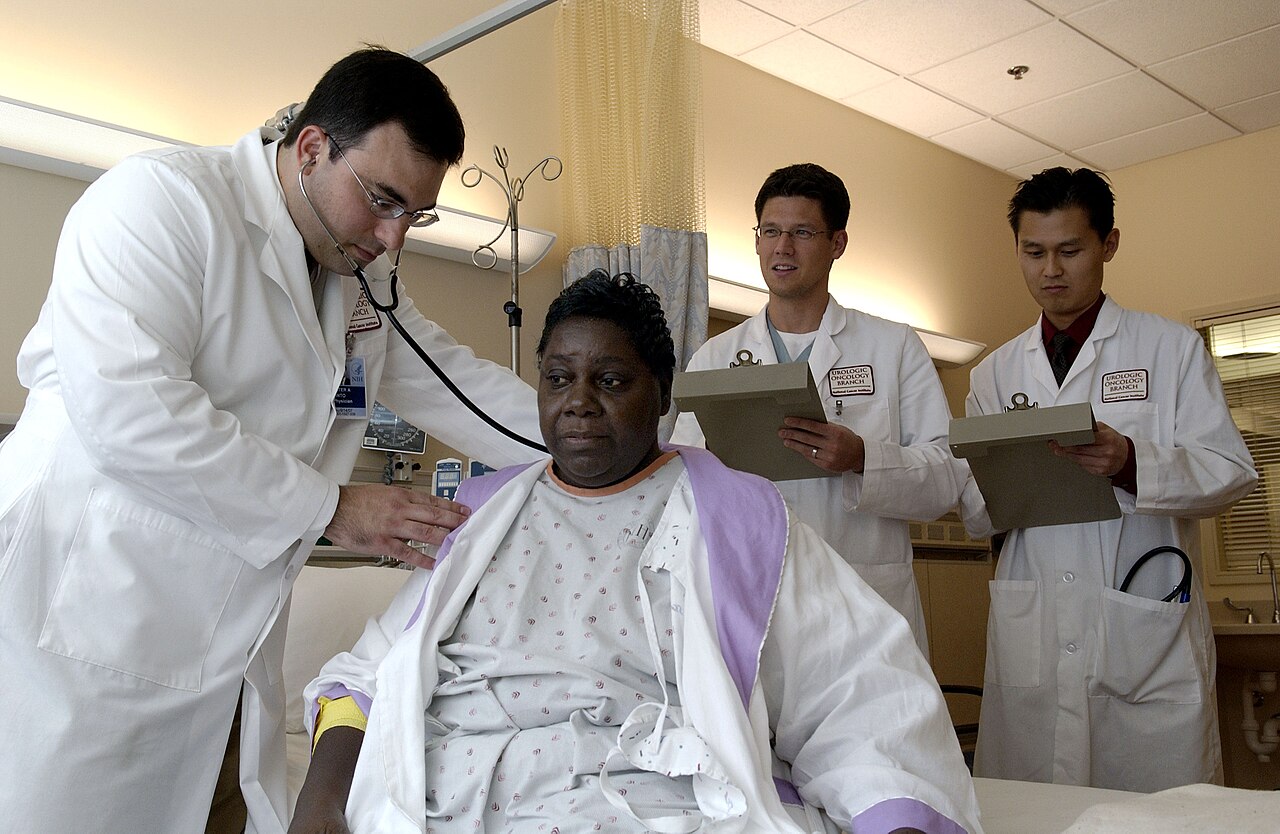 A doctor listening to a patient's chest with a stethoscope during an exam