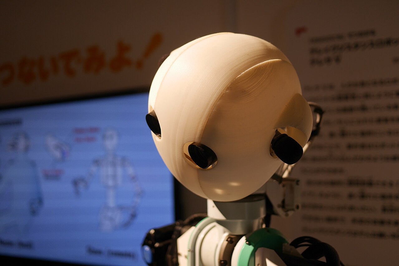 The close-up head of a humanoid telexistence robot with two camera lenses for eyes