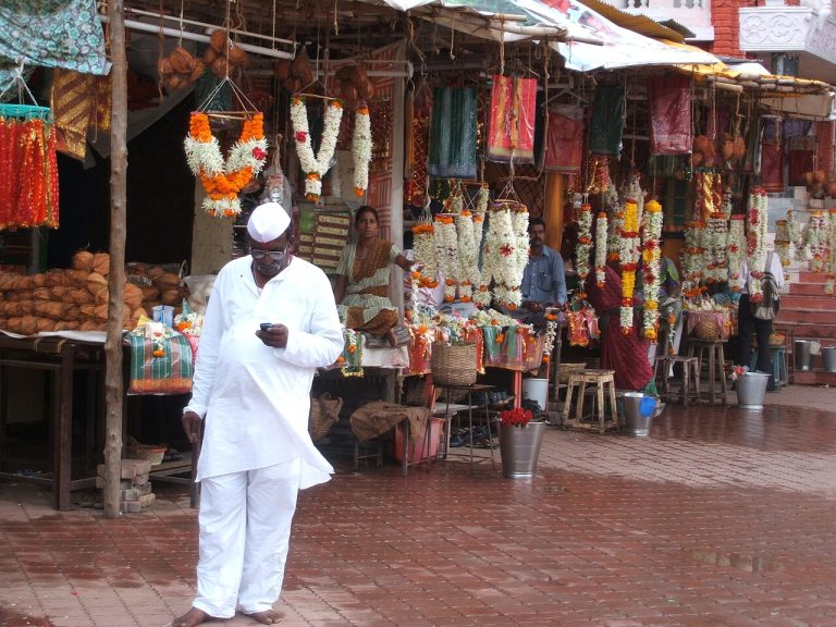 Independent vendors selling flower garlands and goods at market stalls