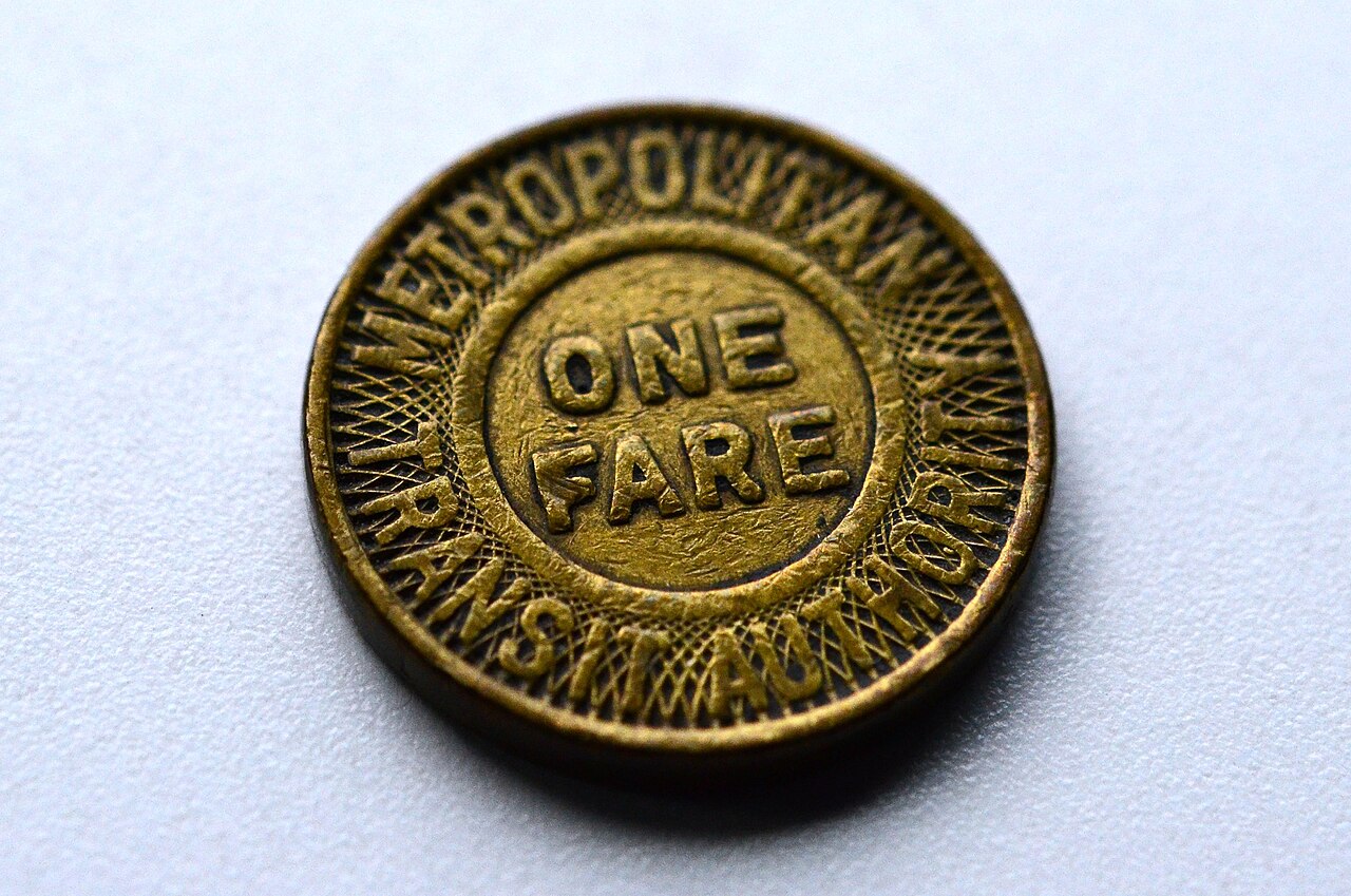 A brass transit token stamped with One Fare, Metropolitan Transit Authority