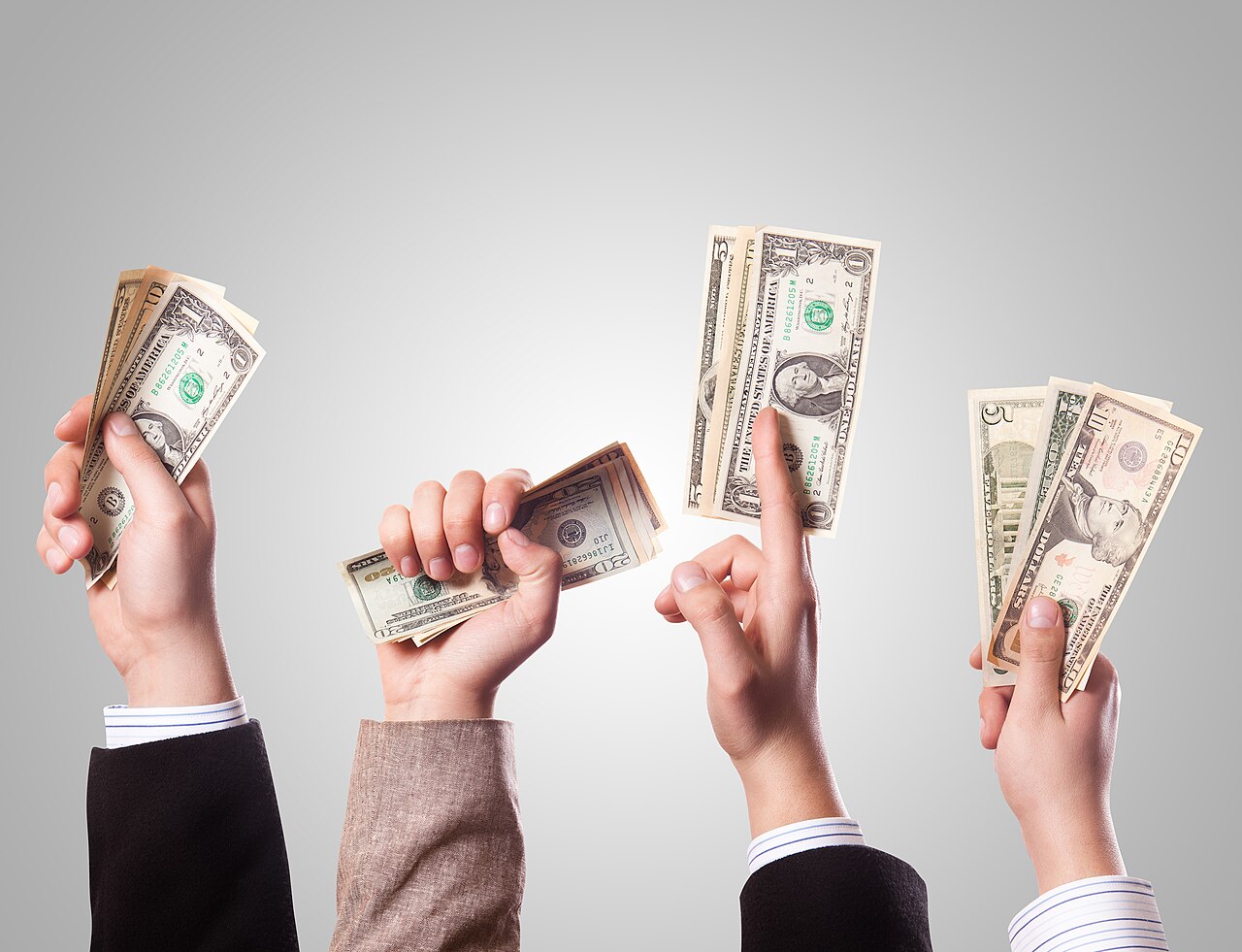 Several raised hands each holding dollar bills against a plain background