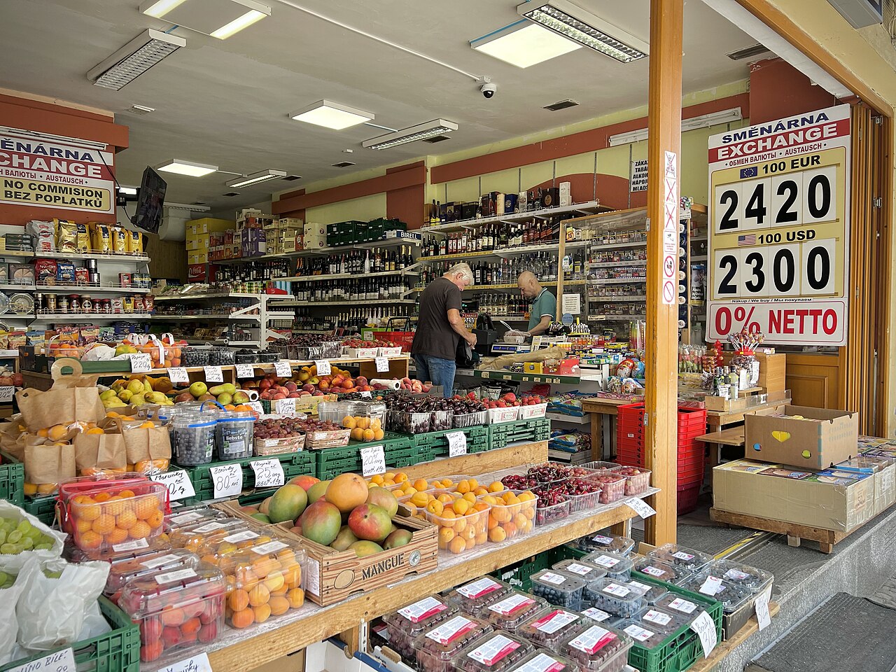 A shop displaying a currency exchange rate board with EUR and USD rates alongside groceries