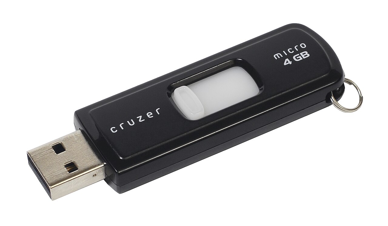 A small black USB flash drive device resembling a hardware wallet