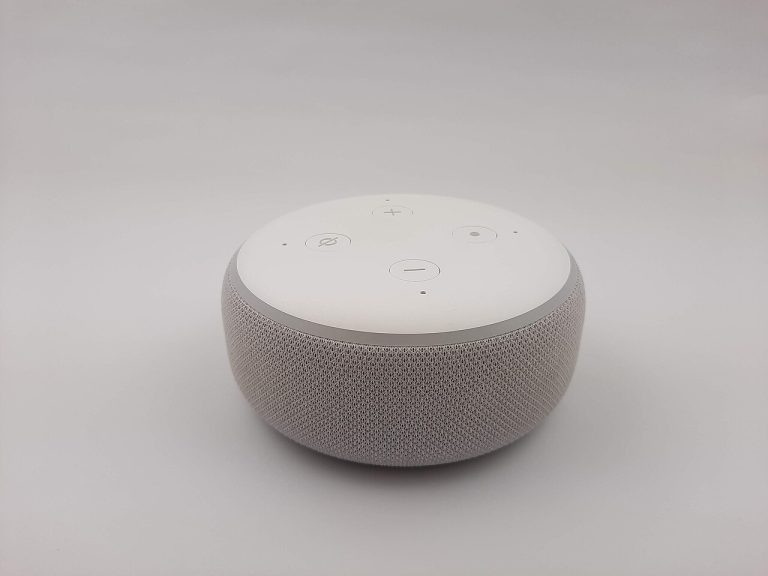 A smart speaker with a voice assistant sitting on a plain background