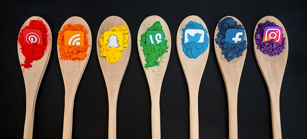 Colorful icons representing different social media platforms arranged on wooden spoons