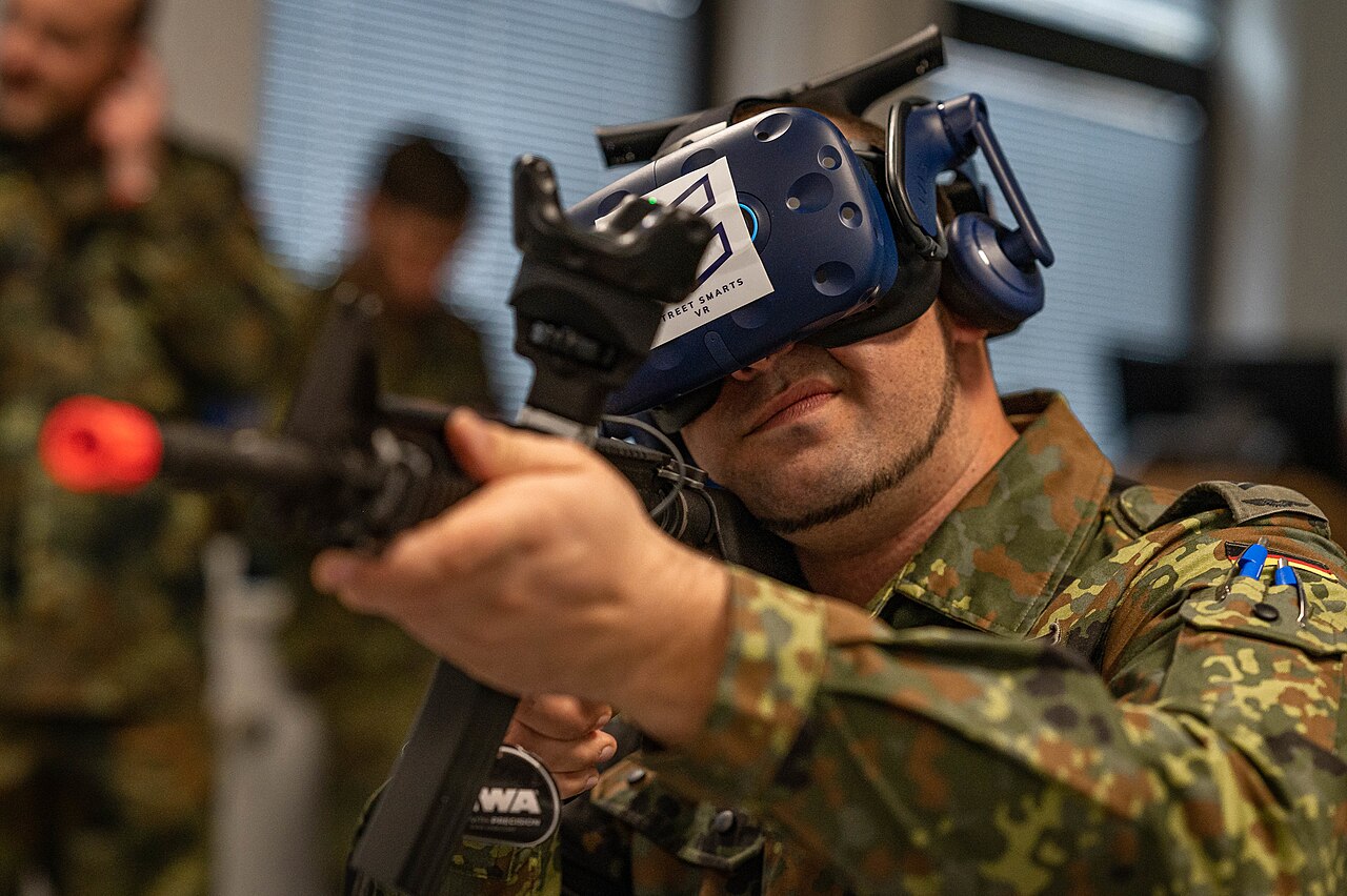 A soldier wearing a VR headset and holding a rifle prop during a virtual reality training simulation
