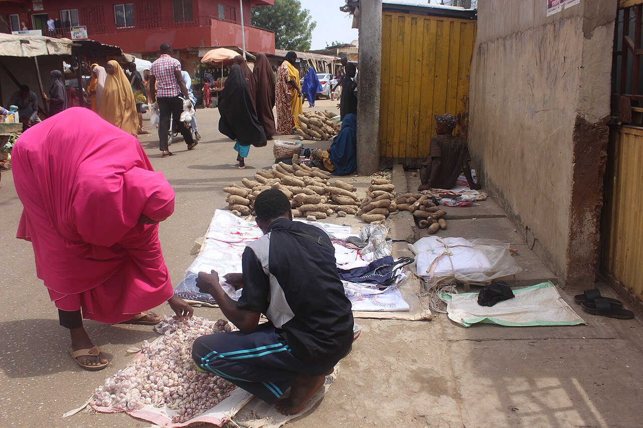 A street vendor selling goods directly to a customer at an outdoor stall