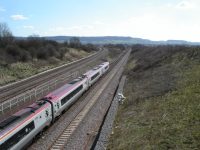 A train traveling along tracks that fork into two diverging paths in the countryside
